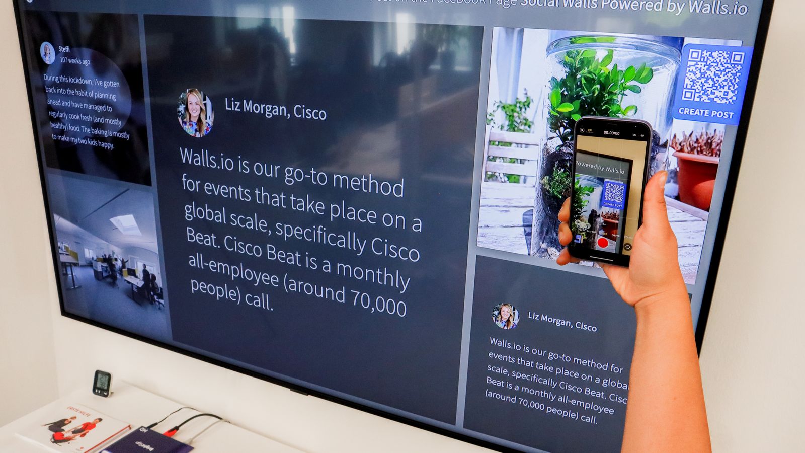 Someone scanning a QR code on a large display with a smartphone to open further information