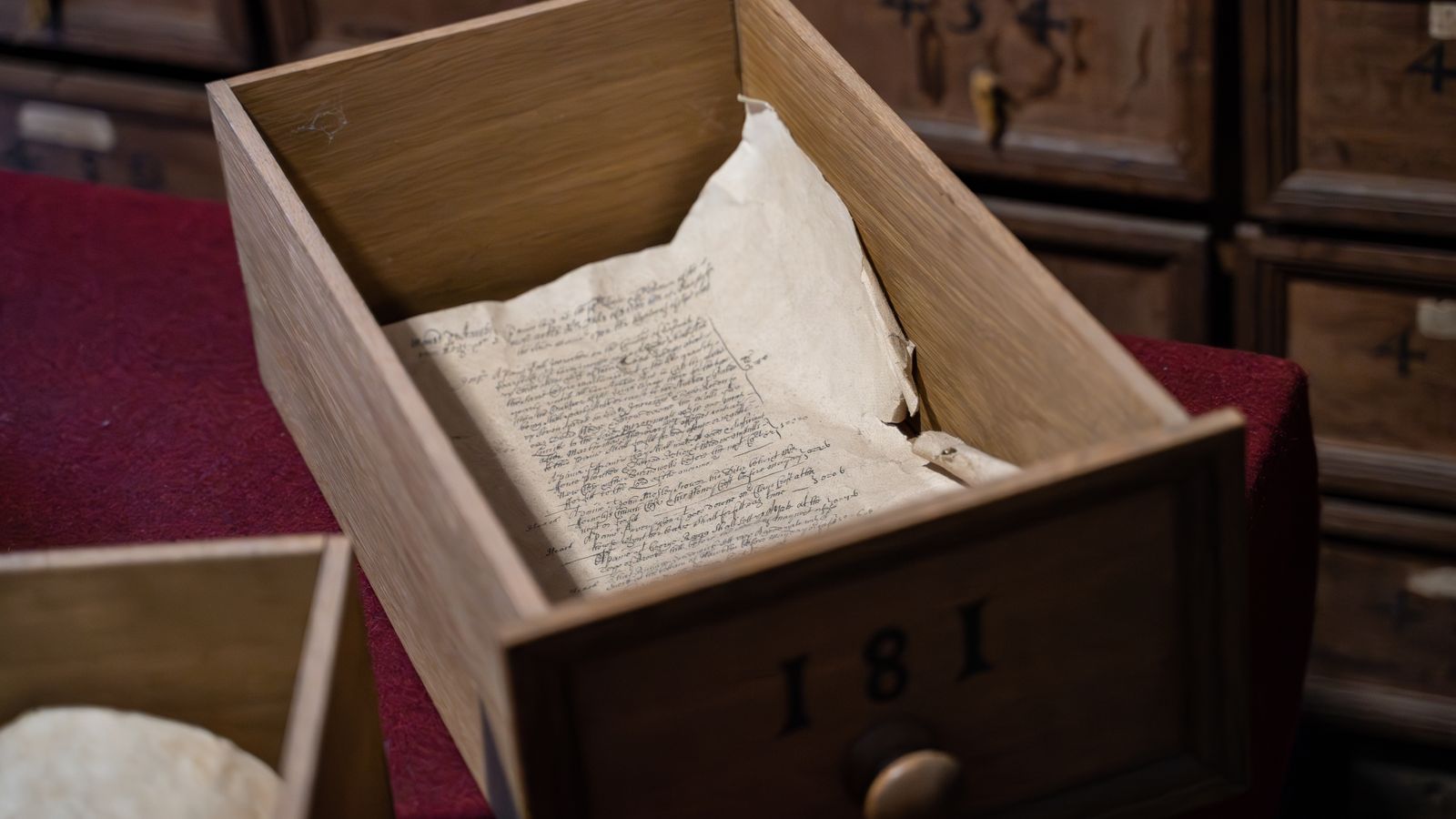 Old handwritten manuscripts in an antique wooden drawer, the kind of family heritage document that should be scanned before it decays